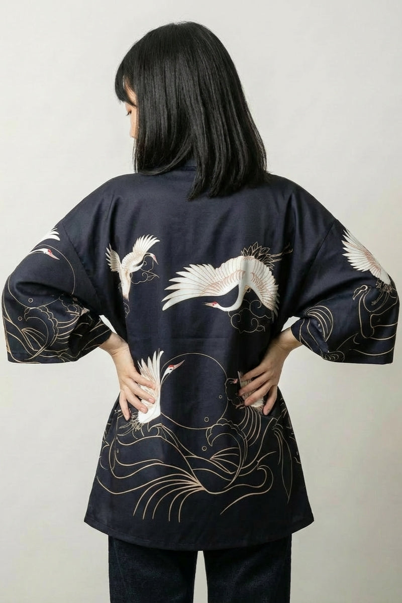 Back view of the black Setsuko short kimono: white cranes gliding low over gilded curling waves