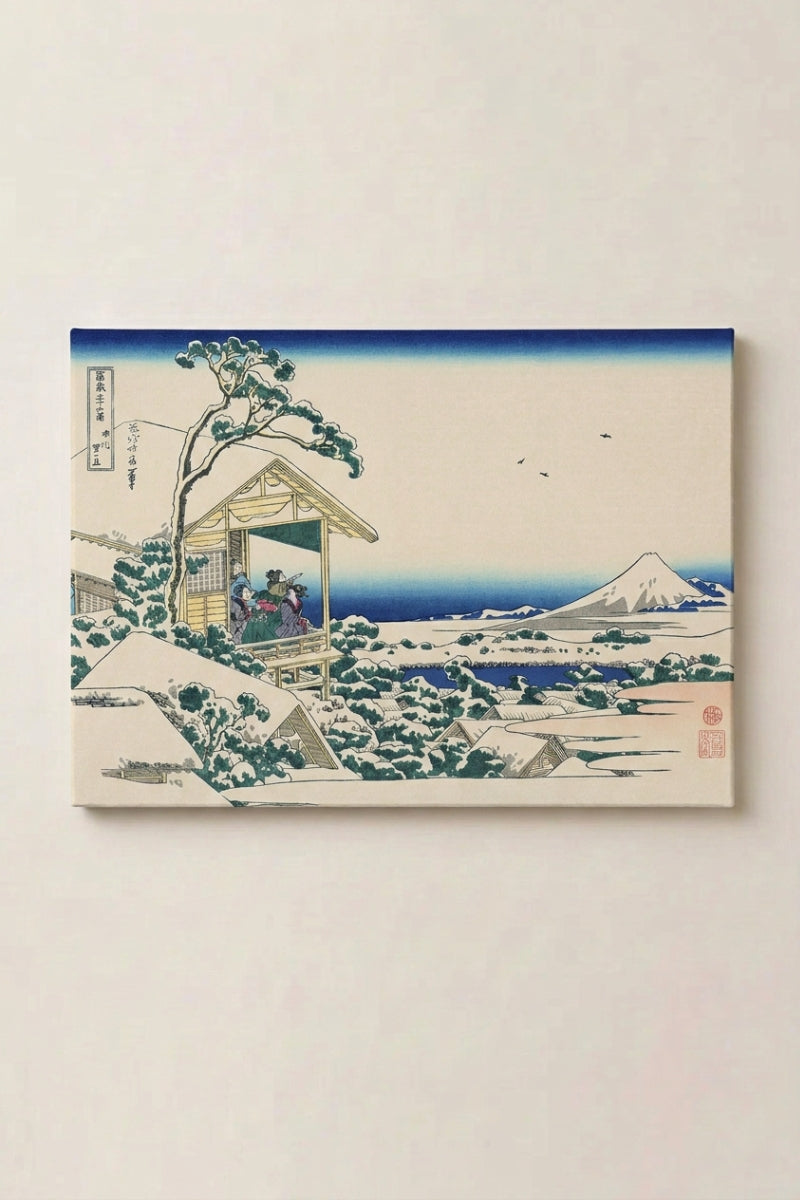 Japanese Snow Print 'Ikube' — Japanese ukiyo-e-style print depicting a snow-covered village by the water with Mount Fuji, ukiyo-e winter canvas print, shown on a wall