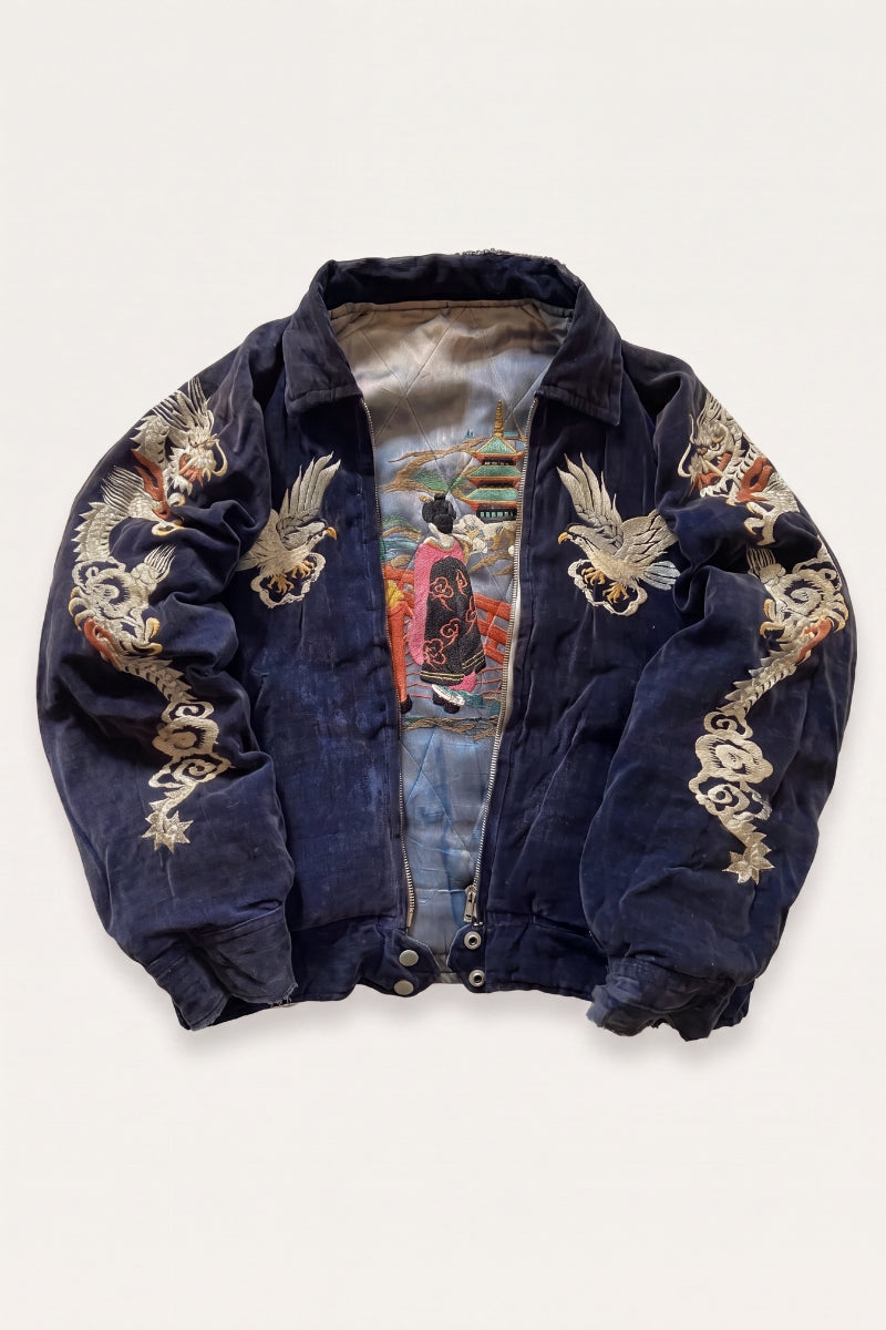 Close detail of the dense dragon embroidery on the suede bomber jacket sleeve
