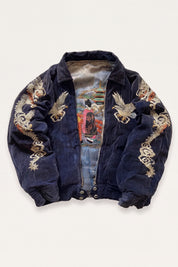 Close detail of the dense dragon embroidery on the suede bomber jacket sleeve