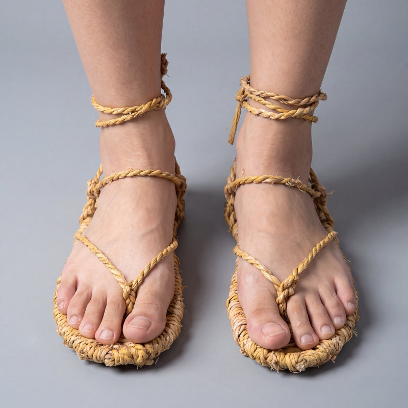 Waraji sandals worn barefoot, front view: handwoven straw soles with rope cords crossing over the instep and tying at the ankle