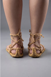 Traditional Japanese waraji sandals on bare feet, front view with the braided straw cords knotted above the ankle