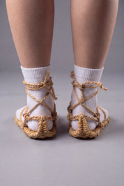 Back three-quarter view of the waraji sandals with white tabi socks, showing how the rope cords wrap and tie behind the ankle