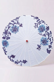 Traditional Japanese paper umbrella with stylized navy and pale blue flowers ringing a bright white canopy, shown open on bamboo ribs