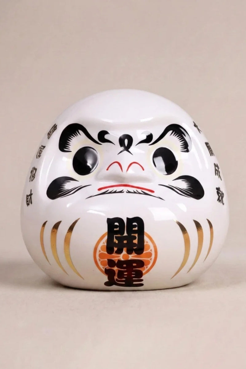 White daruma doll marked kaiun in red with bold black brows, Japanese good-luck charm