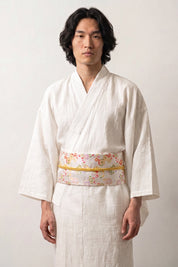 White and silver brocade obi belt with tiny red, green and violet flowers and a gold cord, worn over a kimono