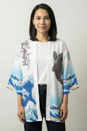 Women's kimono blouse Kanagawa in white, front view: a black koi carp rides Hokusai's great wave in blue and white across the open front and three-quarter sleeves