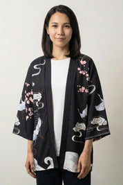 Women's silk kimono jacket Osaka in black, front view: open satin-finish jacket with three-quarter sleeves and white crane detail