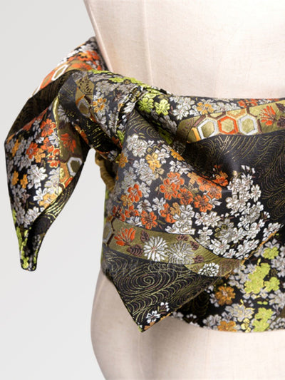A traditional camel colored obi belt for women with a floral pattern