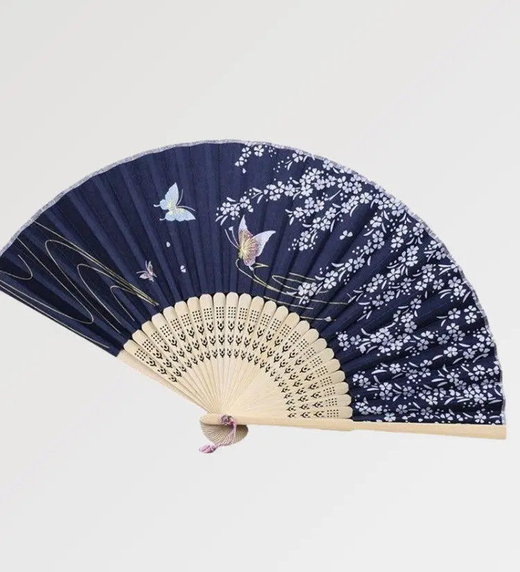 Japanese wooden fan decorated with luminous butterflies in a blue night
