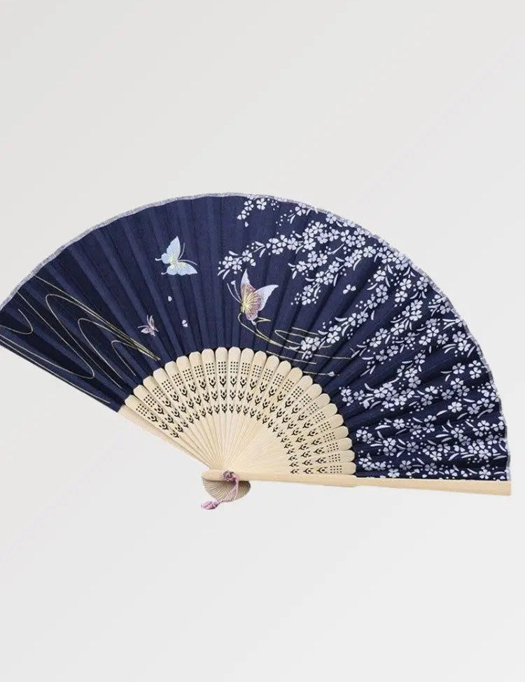Japanese wooden fan decorated with luminous butterflies in a blue night