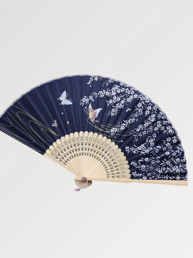Japanese wooden fan decorated with luminous butterflies in a blue night
