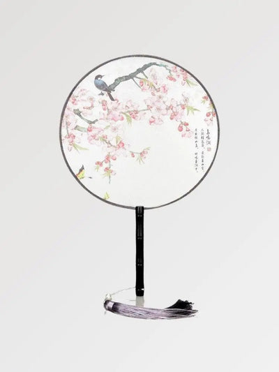 A round Japanese fan with white fabric in a pattern of flowers and birds