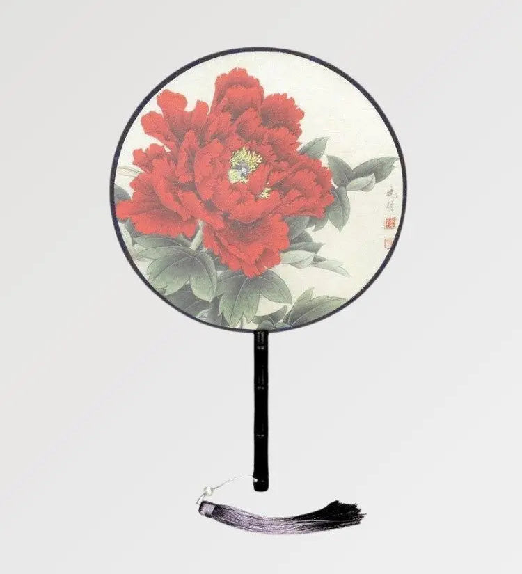 A round Japanese fan with a rose pattern to fan yourself in summer