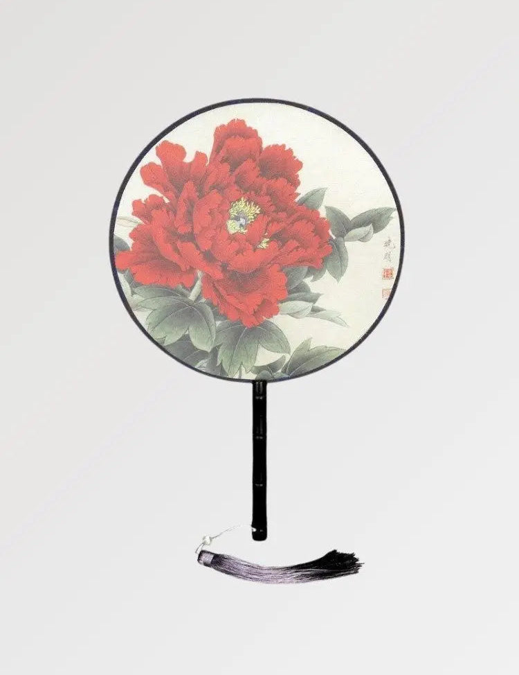 A round Japanese fan with a rose pattern to fan yourself in summer