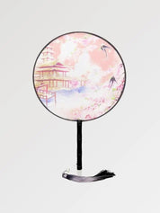 A round Japanese fan with a traditional temple design