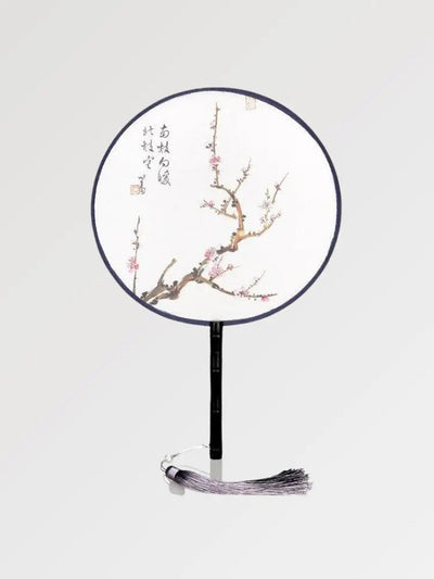 A round fan with Japanese writings decorated with a branch where sakura flowers