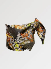 Dark brocade obi belt with orange and white chrysanthemums, green foliage and golden tortoiseshell, flat product view showing the full sash and knot