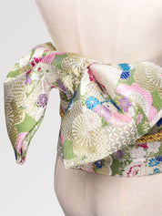 Pastel brocade obi belt with pink, green and blue flowers and gold thread, close detail of the woven fabric and pattern