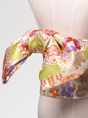 Ivory and gold brocade obi belt with large green leaves, violet and red flowers and golden fans, close detail of the woven fabric and pattern
