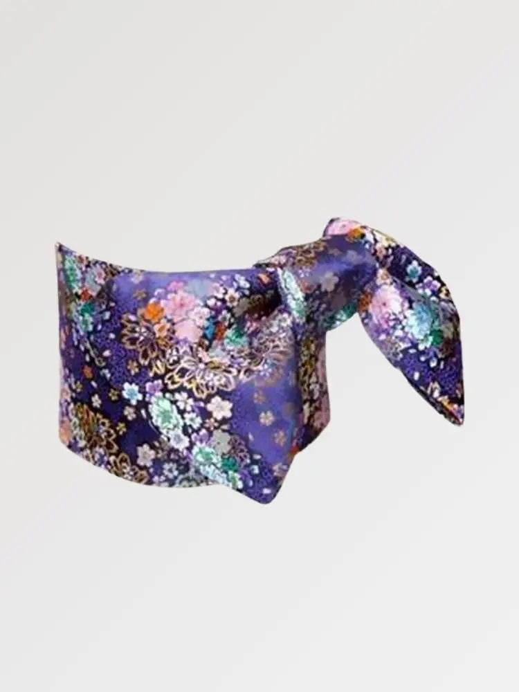 Violet-navy brocade obi belt with pink and white cherry blossoms and chrysanthemums and gold detail, flat product view showing the full sash and knot