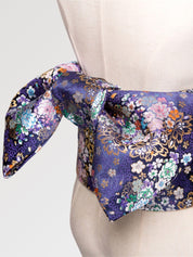 Violet-navy brocade obi belt with pink and white cherry blossoms and chrysanthemums and gold detail, close detail of the woven fabric and pattern